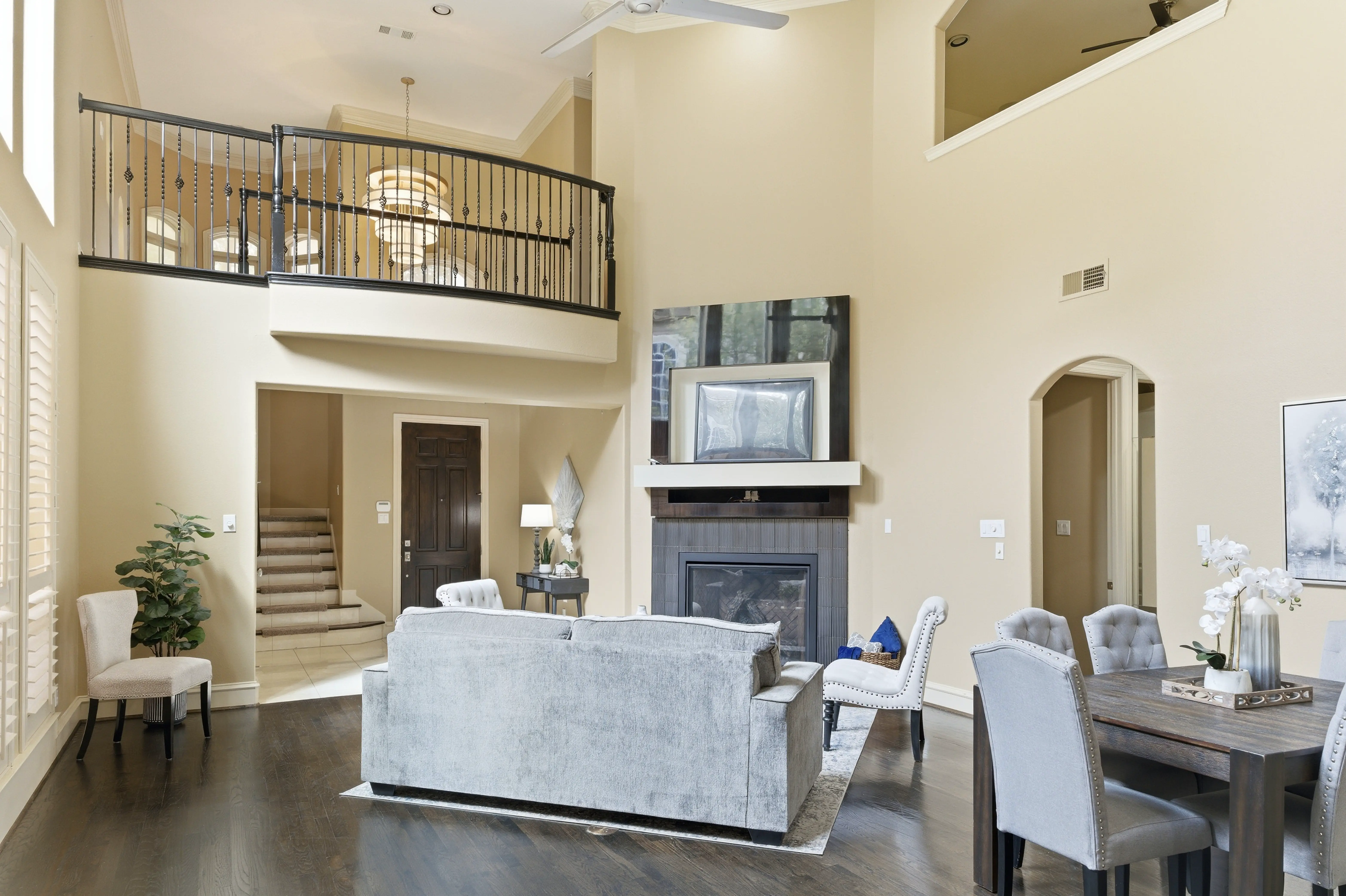 Living room with fireplace, two-story ceiling, and balcony
