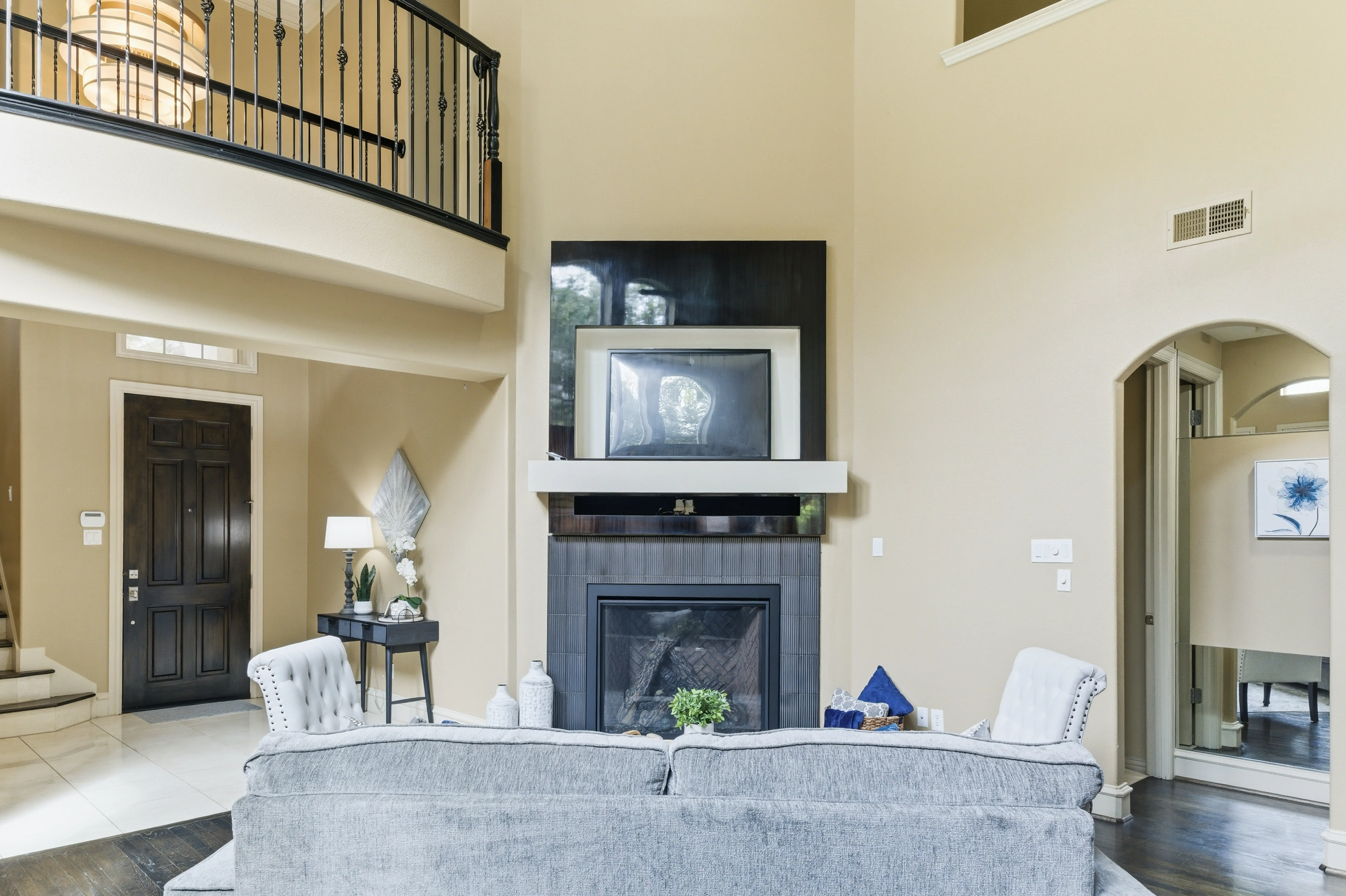Living room fireplace with mounted TV and balcony above