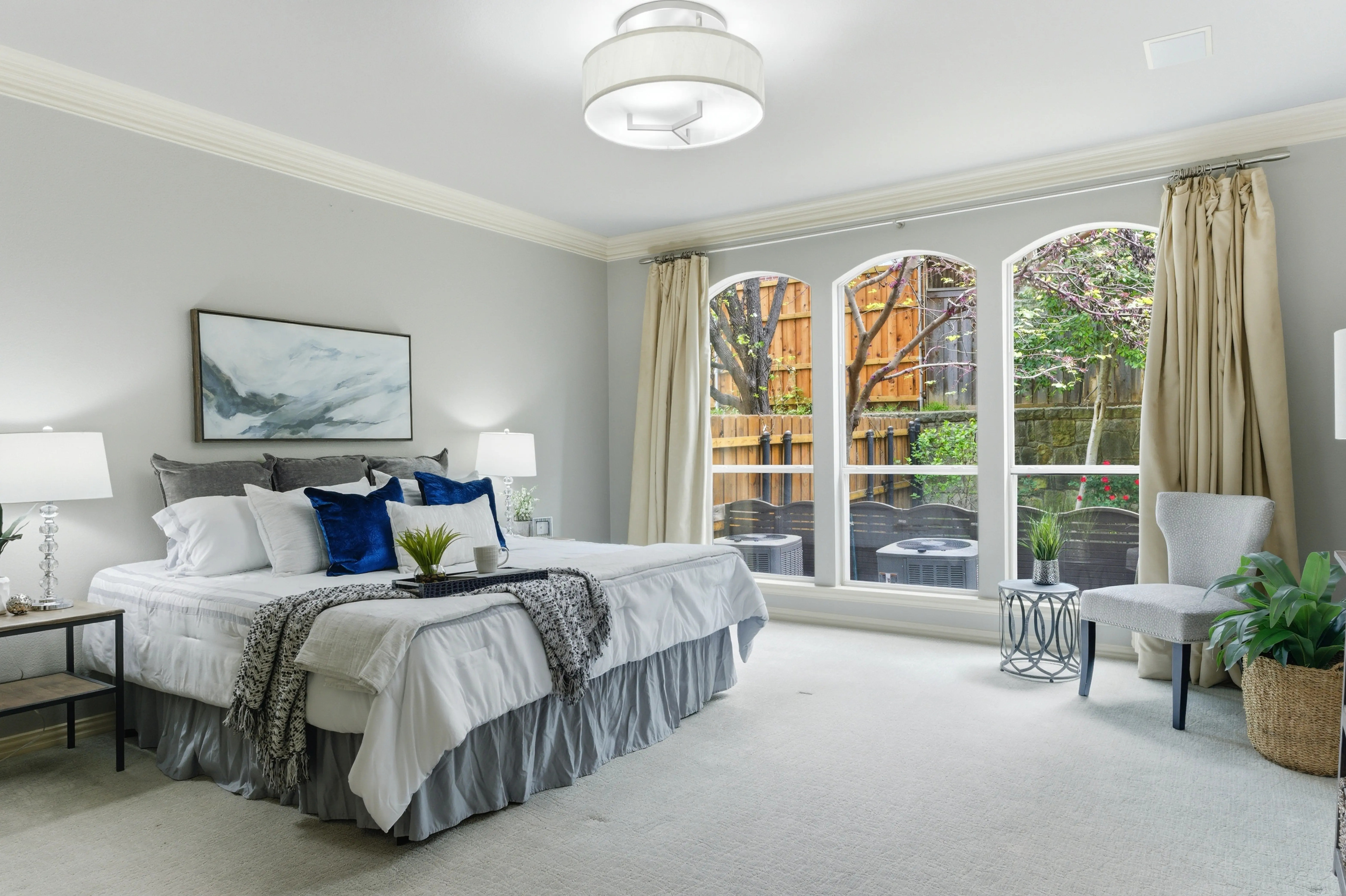 Primary bedroom with arched windows and crown molding