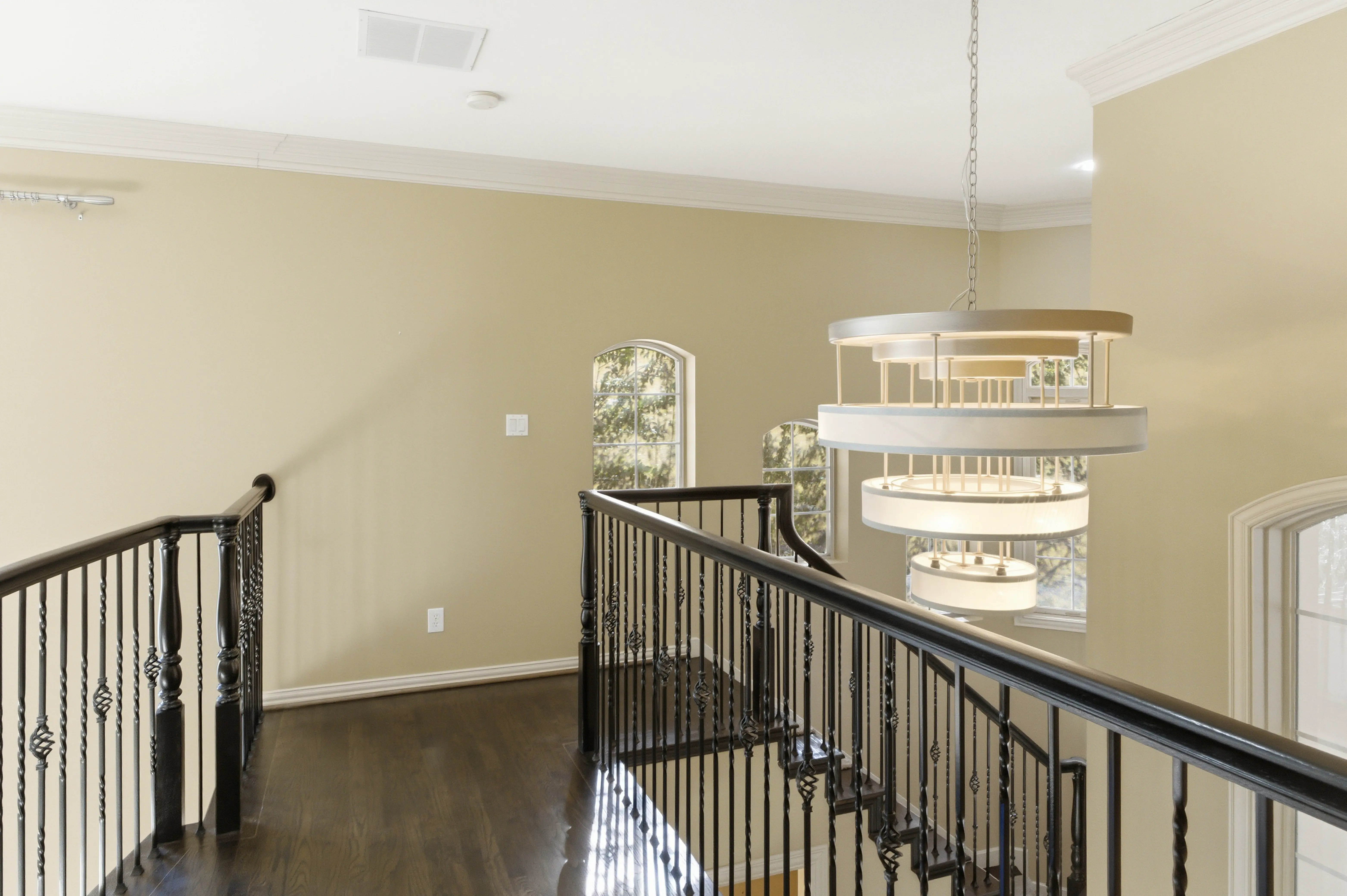 Second-floor landing with iron railing and chandelier