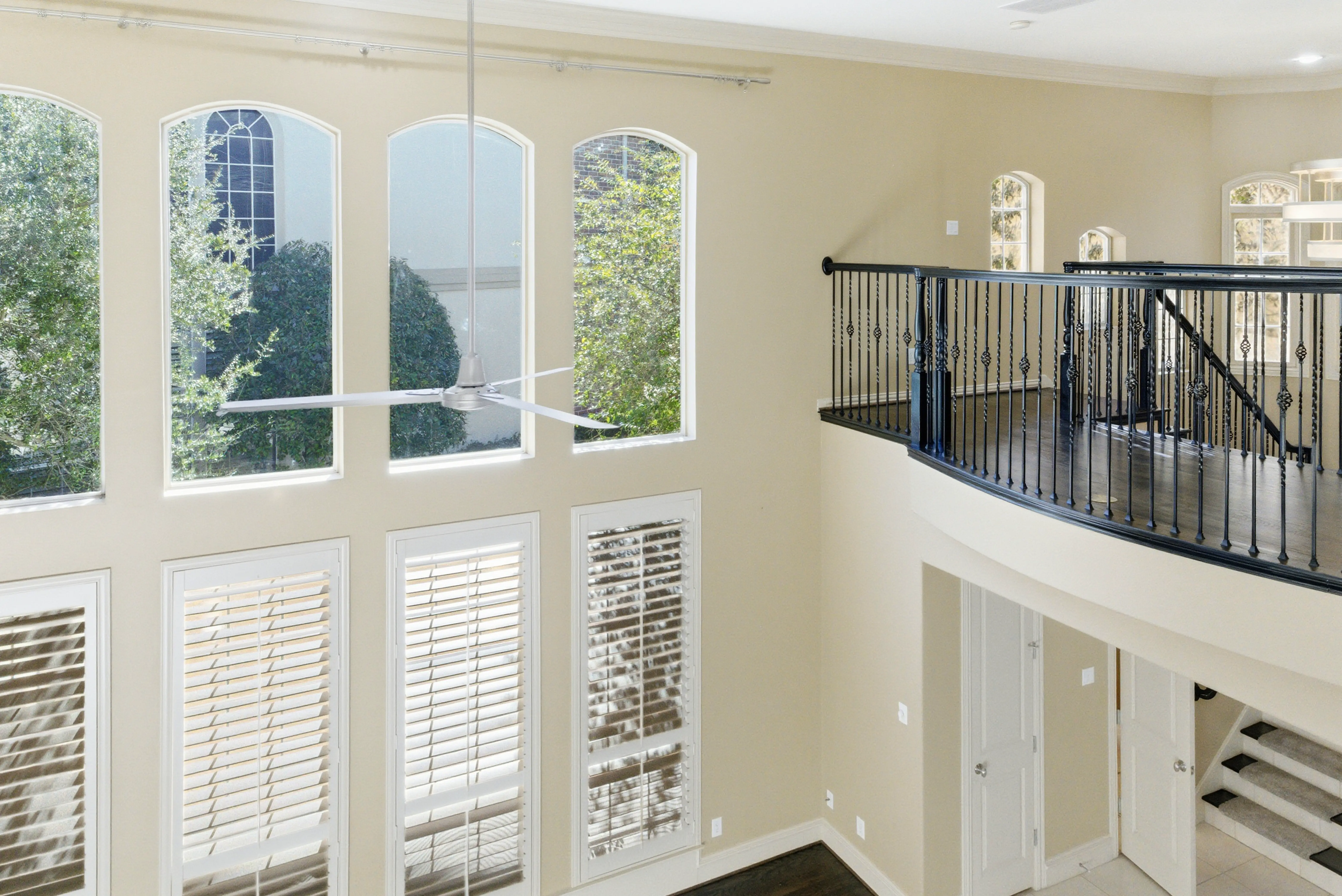 Second-floor view of arched windows and iron railing